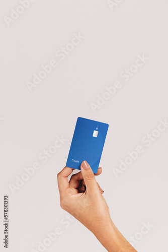 Cashless lifestyle: Female hand holds up a credit card in a studio