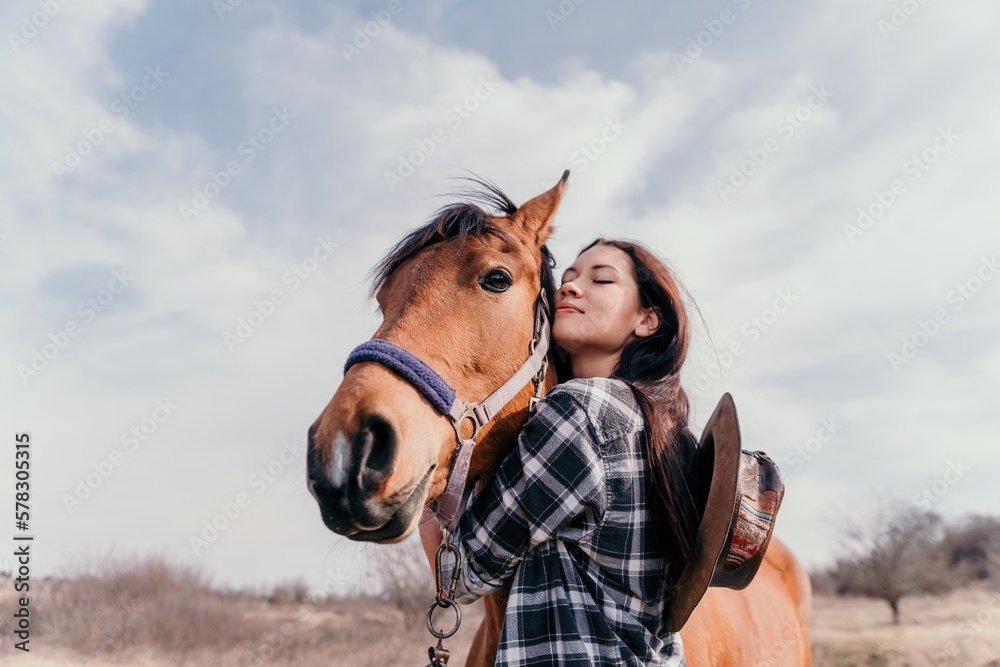 Obraz premium Young happy woman with her horse in evening sunset light. Outdoor photography with fashion model girl. Lifestyle mood. oncept of outdoor riding, sports and recreation.