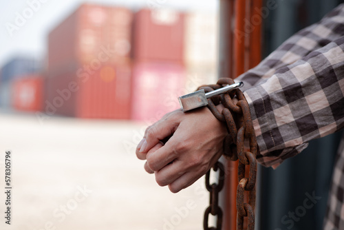  woman's hand trapped in an illegally smuggled container locked with chain and key. Efforts to escape from the confinement were tortured : Human Trafficking and Illegal Immigration.