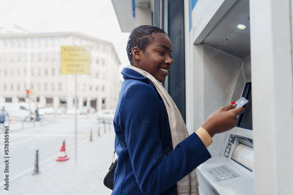 Young african woman withdrawing cash at the ATM Young african woman withdrawing cash at the ATM