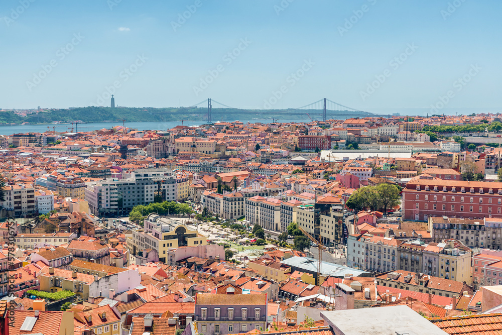 Lisbon, Portugal skyline. Panoramic view of old town of Lisboa city with orange rooftops and bridge on Tagus river.