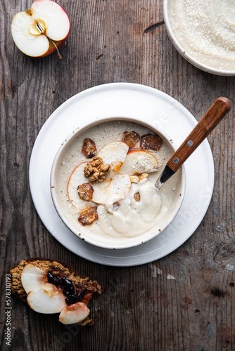 Two bowls of homemade Jerusalem artichoke and apple cream soup and open sandwich with homemade pate with fresh apple and cherry jam on wooden table.