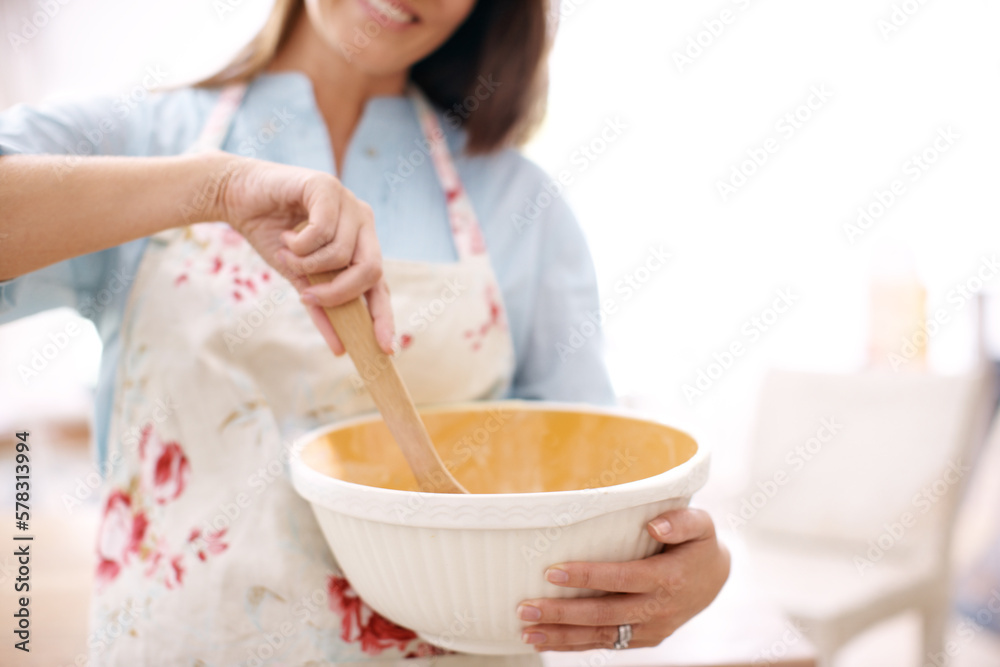 Baking for the family. A woman stirring some cake mix in the kitchen.