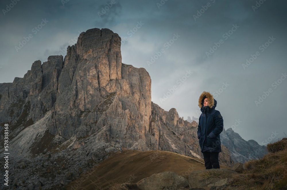 Woman enjoying the top of the mountain, overlooking a snowy range, Dolomites Italy Woman enjoying the top of the mountain, overlooking a snowy range, Dolomites Italy