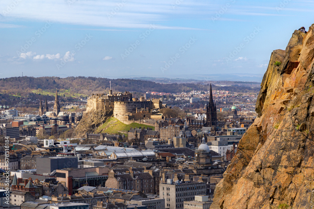 Edinburgh castle bathed in spring sun with Salisbury Crags on right