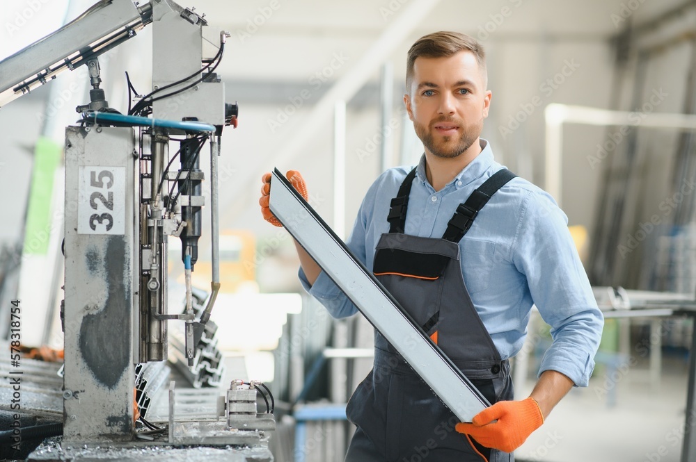 Factory for aluminum and PVC windows and doors production. Manual worker assembling PVC windows and doors Factory for aluminum and PVC windows and doors production. Manual worker assembling PVC windows and doors