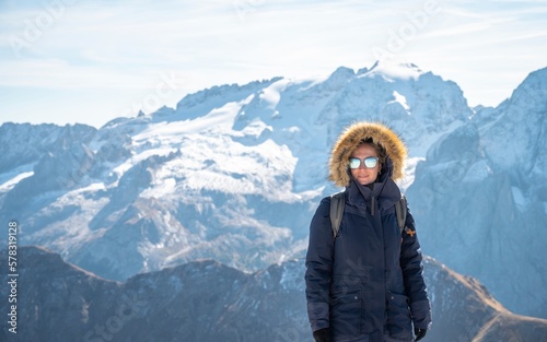 Woman enjoying the top of the mountain, overlooking a snowy range, Dolomites Italy