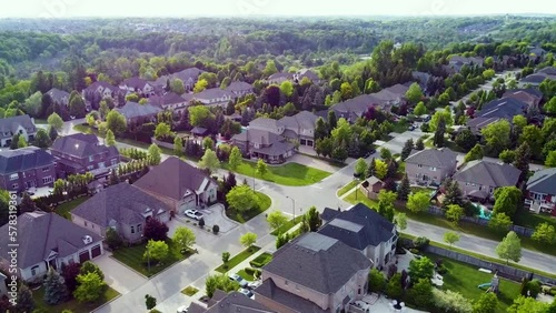 Orbiting drone shot of an intersection of sunny Kleinburg houses. photo