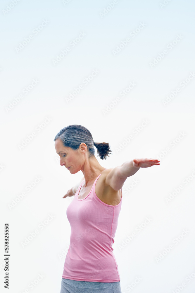 Clearing her mind. an attractive mature woman doing yoga outdoors. Clearing her mind. an attractive mature woman doing yoga outdoors.