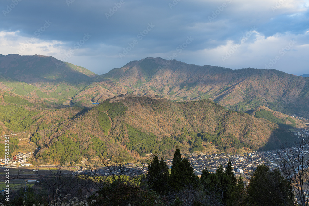 Naklejka premium 日本 兵庫県朝来市の立雲峡テラスから見える早朝の朝日に照らされた竹田城跡