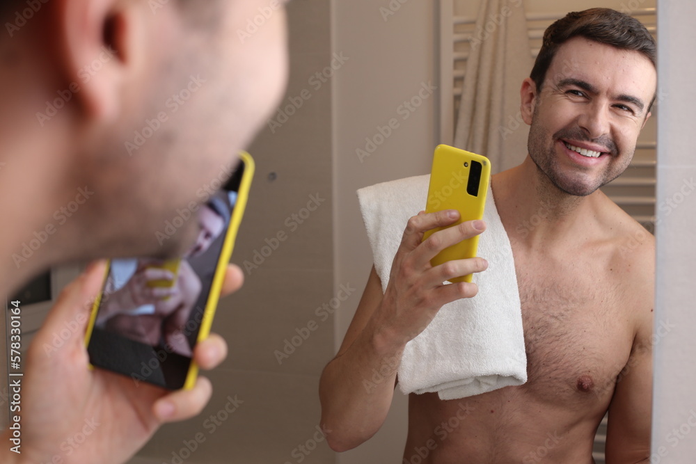Sexy man taking a selfie in bathroom mirror Sexy man taking a selfie in bathroom mirror