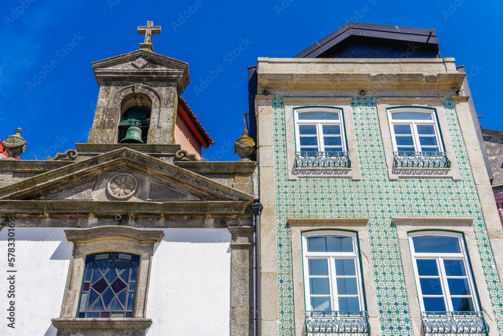 Porto, Portugal Ribeira church next to a house. Day view of facade with house with traditional Portuguese Azulejo tiles.