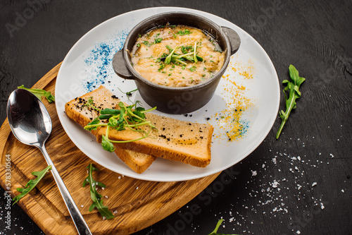 Fresh onion cream soup and crottons on wooden background