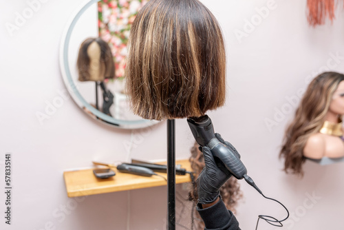 cutting the wig on the mannequin head by electric trimmer photo