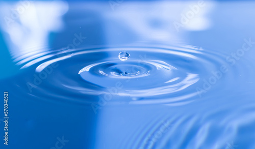 clear water droplets with circular waves Slightly blurred blue splash water drop, natural water drop concept and use it as background.