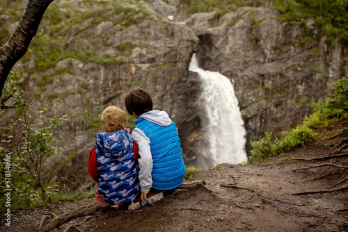 Happy european family with kids and dog, enjoying the hike to Manafossen waterfall summertime photo