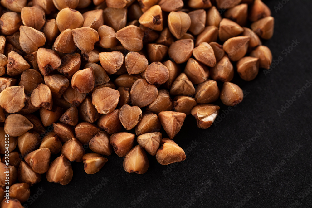 Buckwheat groats on a black background. Macro. Close-up Buckwheat groats on a black background. Macro. Close-up