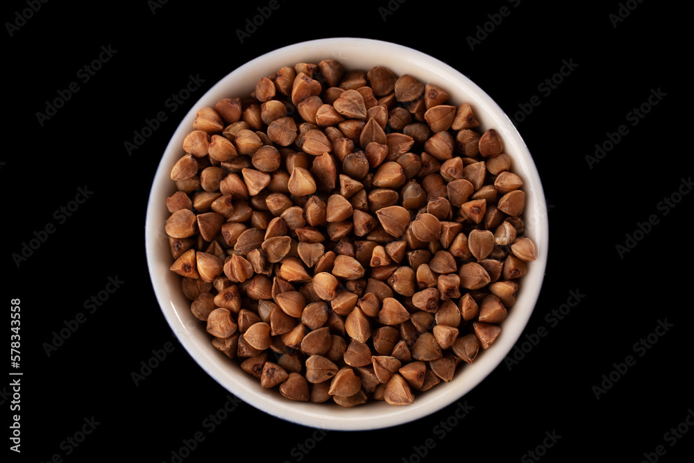 Buckwheat groats on a black background. Macro. Close-up