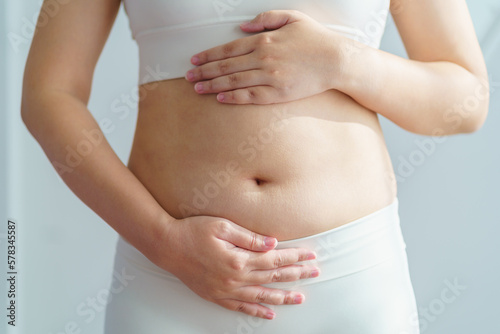 Women body fat belly. Obese woman hand holding excessive belly fat. diet lifestyle concept to reduce belly and shape up healthy stomach muscle.