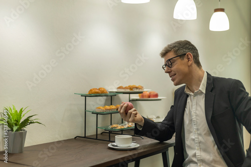 Businessman is taking coffee or beverage in a co=working space or VIP lounge to refresh before taking next job. Male officer is happy to have a cup of coffee at a breakfast counter