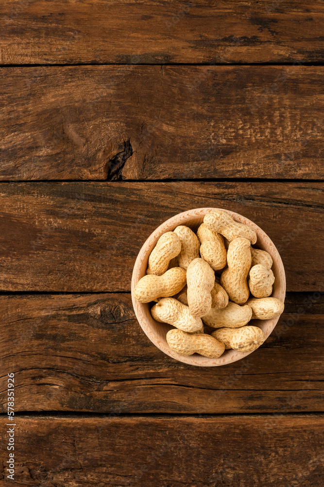 Tasty peanuts in bowl on wooden background with copyspace. Top view Tasty peanuts in bowl on wooden background with copyspace. Top view
