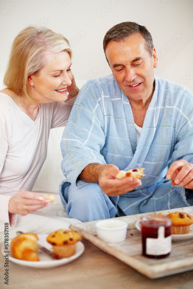 Couple having breakfast with a mature man applying jam. Portrait of a happy couple having breakfast with a mature man applying jam.