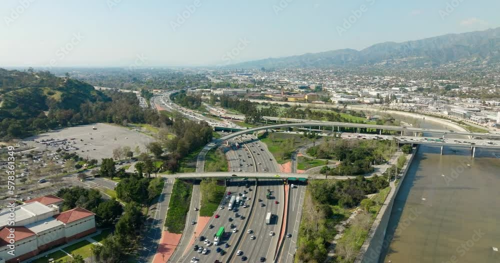 Beautiful aerial view to the cars driving on multi-level highway in Los Angeles. Traffic on a highway junction. Aerial view of road interchange or highway intersection with busy urban traffic. 