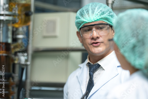 Pharmaceutical factory woman worker in protective clothing operating production line in sterile environment  scientist with glasses and gloves checking hemp plants in a marijuana farm