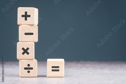 Mathematics operation signs on wood cubes, plus, minus, multiply, divide, and equal sign for calculating or education concept photo