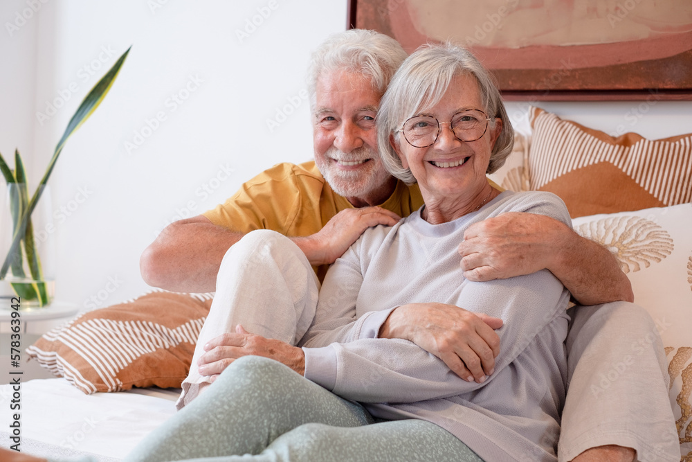 Love lives forever! Senior couple portrait at home. Handsome old man and attractive old woman are enjoying spending time together while lying in bed.