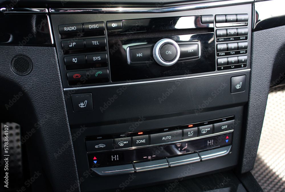 Multimedia radio cd controls. Modern car climate control panel for driver and passenger with shallow depth of field. Zone climate control. Car interior detail.