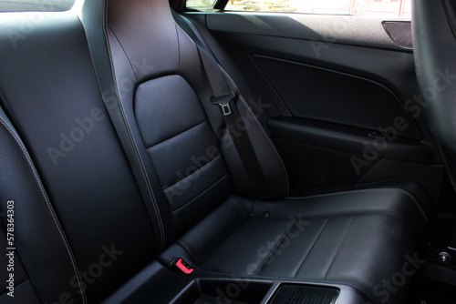 Comfortable black leather car soft clean rear seat. Black Leather interior design, car passenger clean, angle view side. Back passenger seats in modern comfortable car.