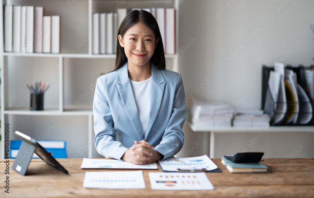 Businesswoman working on her project while sitting in the office room, holding chart and graph paper in her hands. Businesswoman working on her project while sitting in the office room, holding chart and graph paper in her hands.