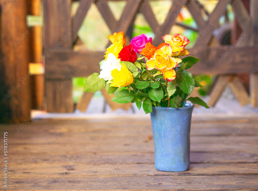 Early spring stil life with a bouquet of colorful roses on the old wooden background. Early spring stil life with a bouquet of colorful roses on the old wooden background.