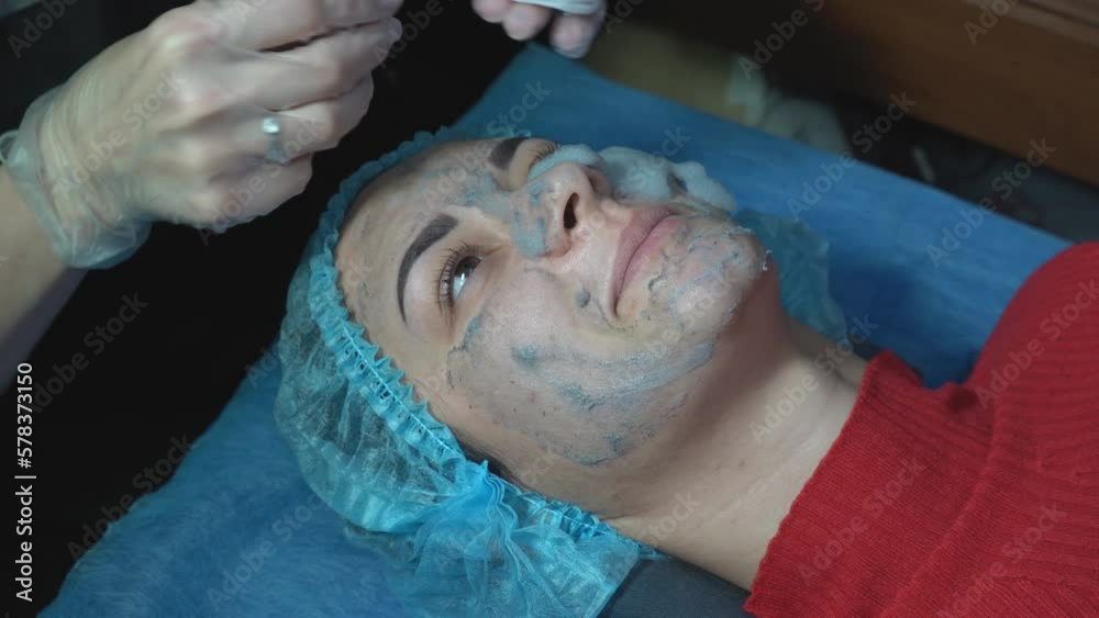 The girl applies a nourishing charcoal mask to reduce wrinkles. Close-up of a woman's face with a blue bubble clay mask. Carbonated bubble clay mask. The girl applies a nourishing charcoal mask to reduce wrinkles. Close-up of a woman's face with a blue bubble clay mask. Carbonated bubble clay mask.