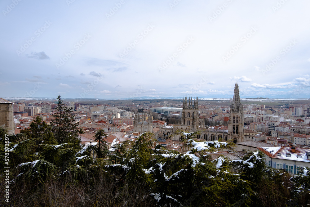 Panorámica desde el mirador del Castillo de Burgos con la catedral en el centro bajo un cielo gris nublado y nieve en los tejados en un día de primavera