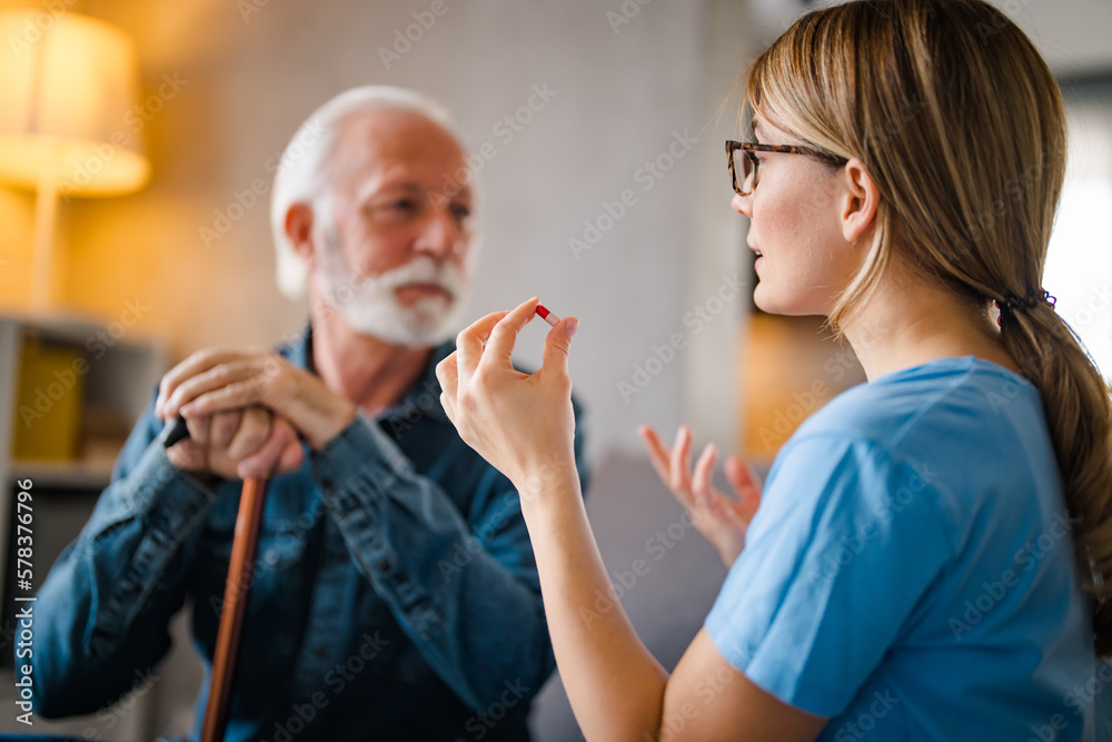 Woman doctor consult prescribe medicines to old male patient at home. Female GP hold bottles pills give prescription medication to mature client on therapy. Elderly healthcare concept. Woman doctor consult prescribe medicines to old male patient at home. Female GP hold bottles pills give prescription medication to mature client on therapy. Elderly healthcare concept.