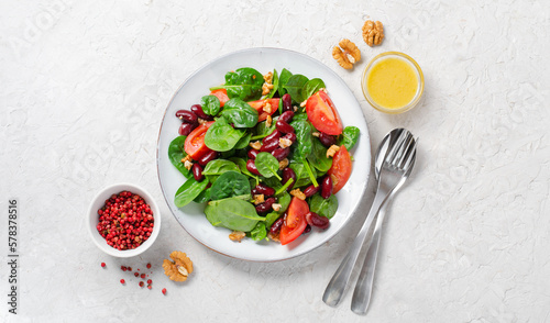Red Bean Salad On Bright Background, Fresh Salad with Spinach, Cherry Tomatoes, Walnuts, Beans and Mustard Dressing