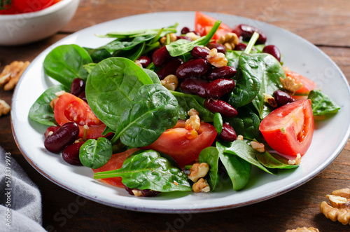 Red Bean Salad On Wooden Background, Fresh Salad with Spinach, Cherry Tomatoes, Walnuts, Beans and Mustard Dressing