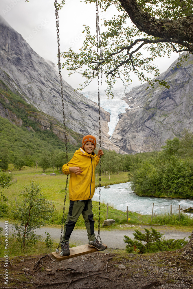 Naklejka premium Child, cute boy, toddler enjoying the amazing view of the glacier in.Jostedalsbreen national park