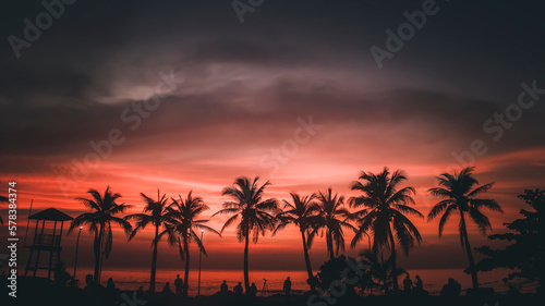 Silhouette coconut palm trees on the beach and sunset in a vintage tone. Beautiful tropical beach with palm tree silhouettes at Sea. Silhouette of the coconut palm tree on the sea and sunset