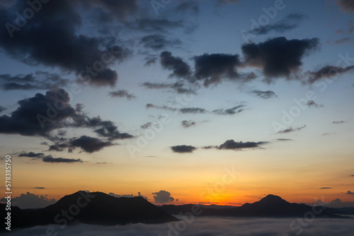 Beautiful sunset above mountains; the forest at orange sunset