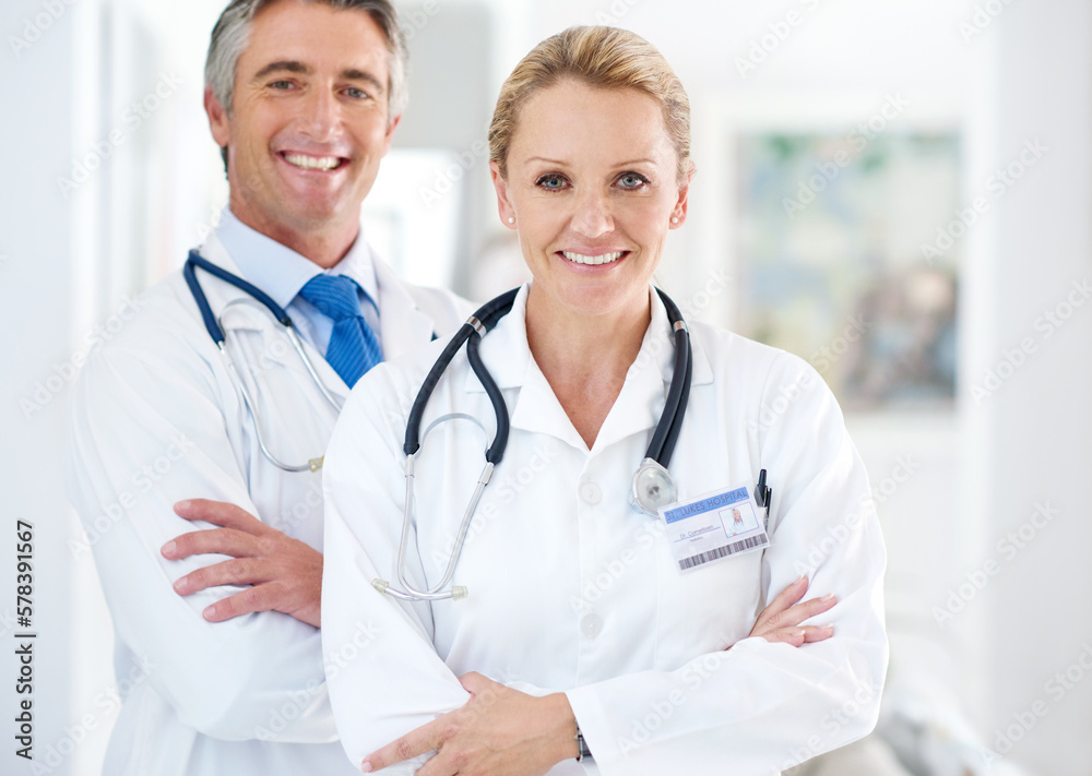 Youre in good hands. Portrait of two doctors standing in a hospital corridor. Youre in good hands. Portrait of two doctors standing in a hospital corridor.