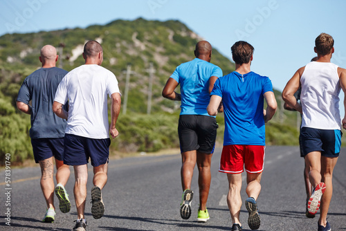 There to motivate each other along the way. Rearview shot of a group of men running a marathon.