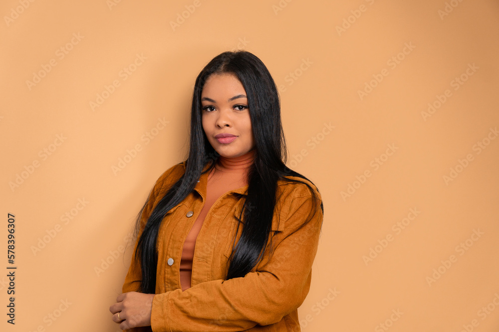 confident black woman with arms crossed in beige colors. portrait, real people concept. confident black woman with arms crossed in beige colors. portrait, real people concept.
