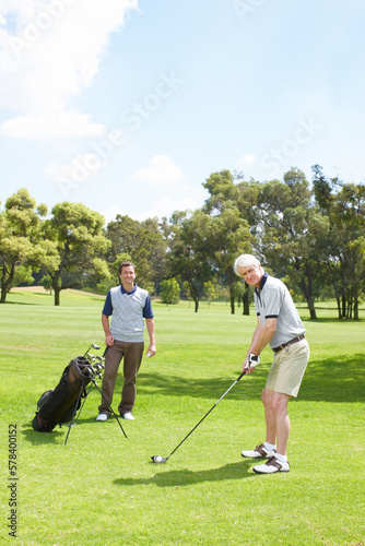 They enjoying spending time together on the course. Golfing companions out on the course playing a round of golf.