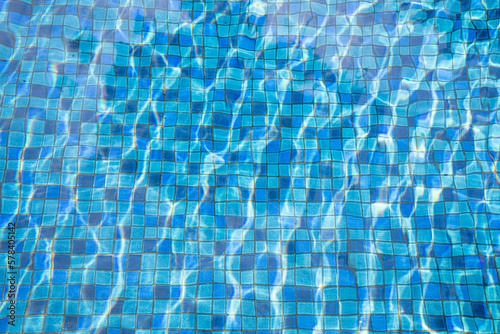 Clear swimming pool with blue ceramic tiles for background.