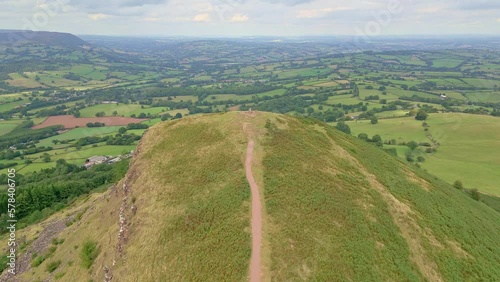 Aerial view flying over a mountain ridge surrounded by rural farmland (Skirrid Fawr) photo