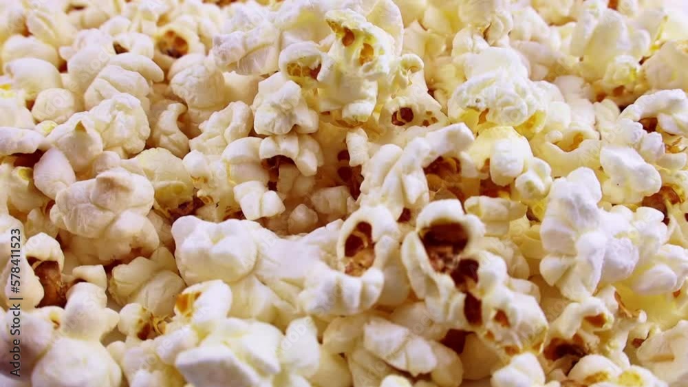 White and yellow fresh salted popcorn falling down close up White and yellow fresh salted popcorn falling down close up