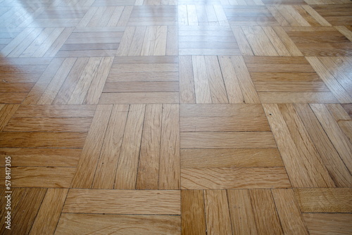 Wooden tile apartment flooring or parquette. Low and ultra wide angle view, no people, natural window light